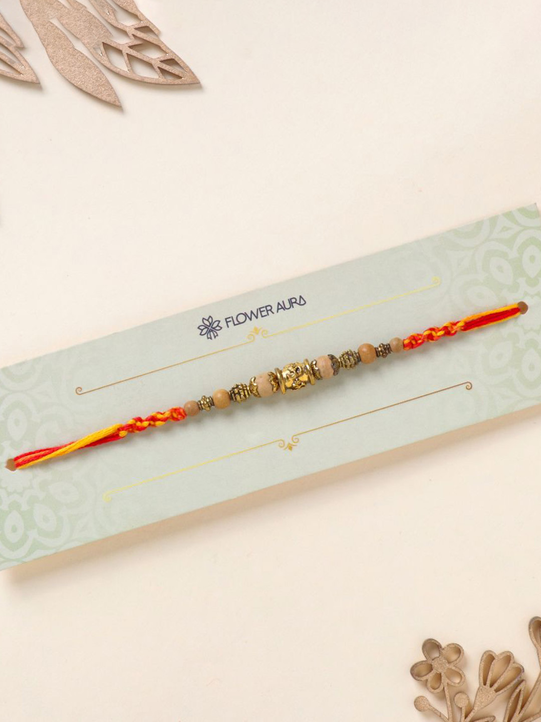 

Floweraura Stone Studded & Beaded Thread Rakhi With Roli Chawal, Gold
