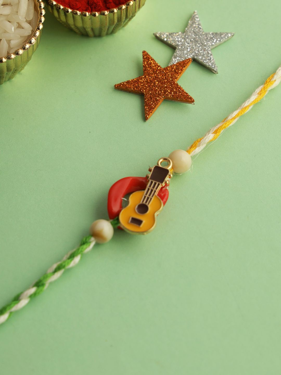 

Kook N Keech Yellow Little Guitar Twisted Thread Rakhi With Roli Chawal & Greetings Card