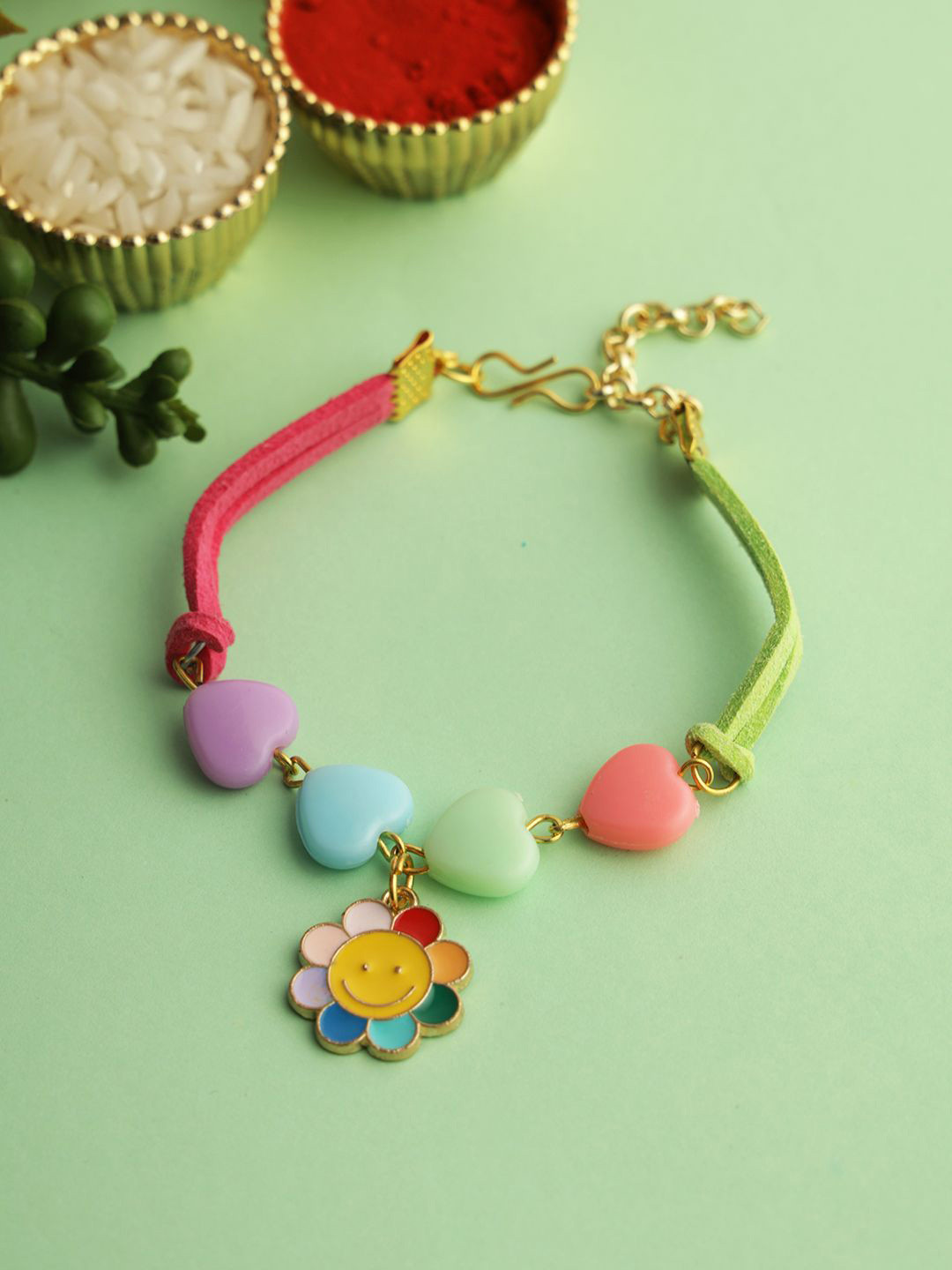 

Kook N Keech Yellow Heart & Floral Designed Charm Bracelet Rakhi With Roli Chawal