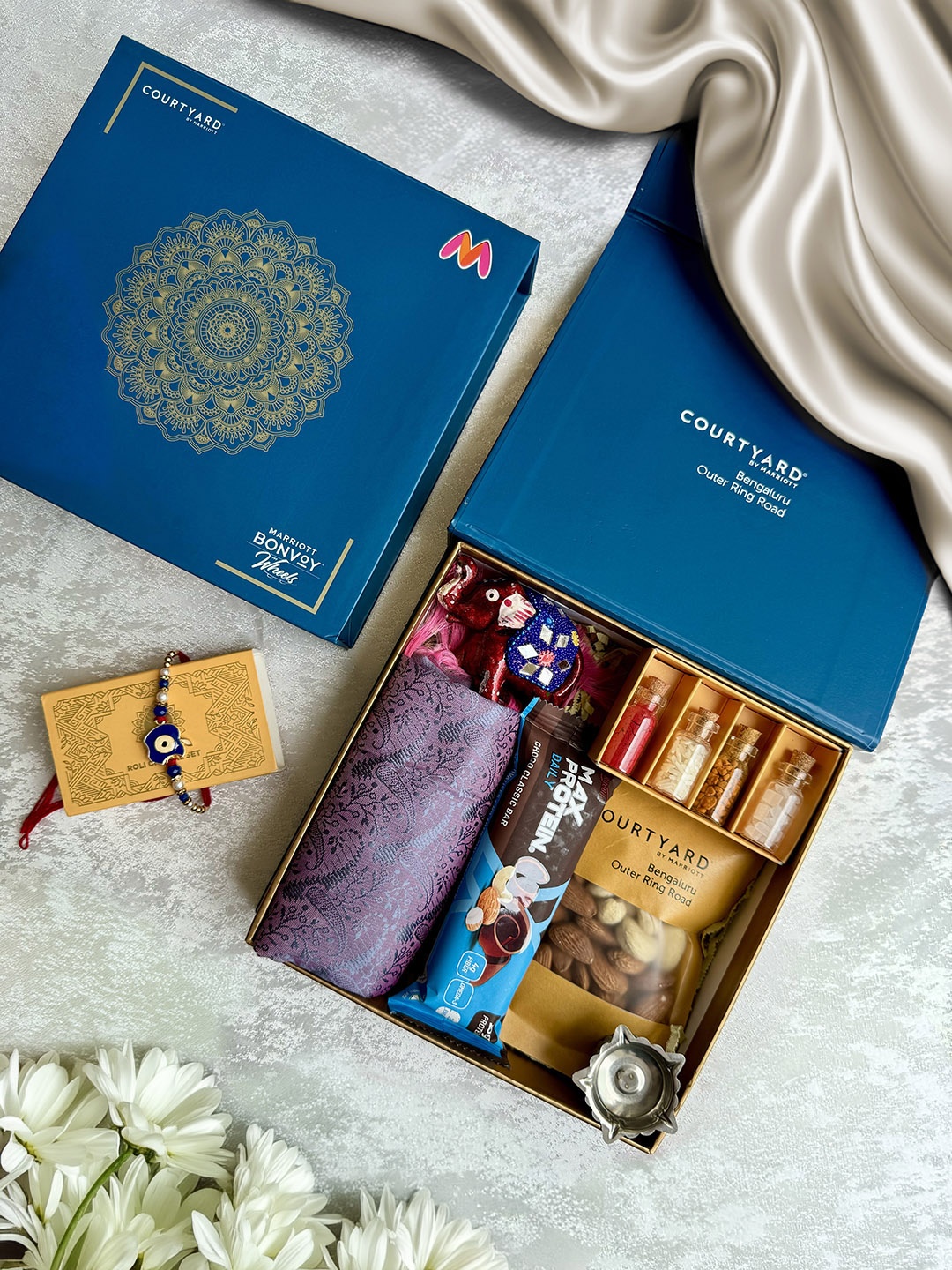 

Courtyard by Marriott - BLR ORR 7Pcs Rakhi With Assorted Gift Hamper, Blue