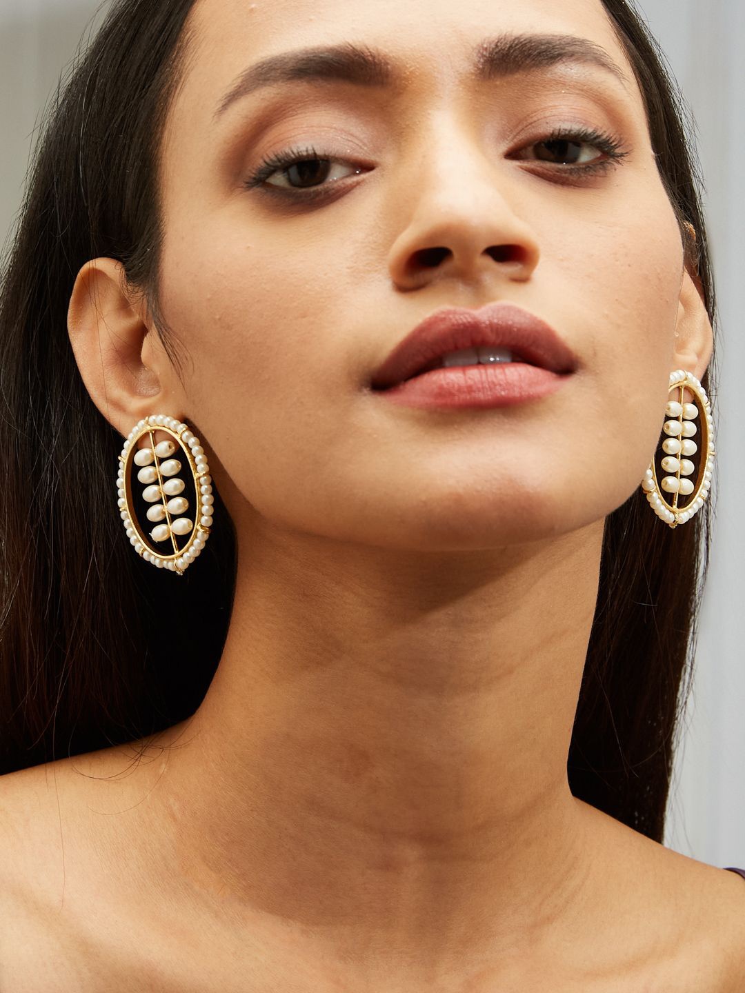

Yinara Gold Plated Pearls Studded Oval Shaped Drop Earrings