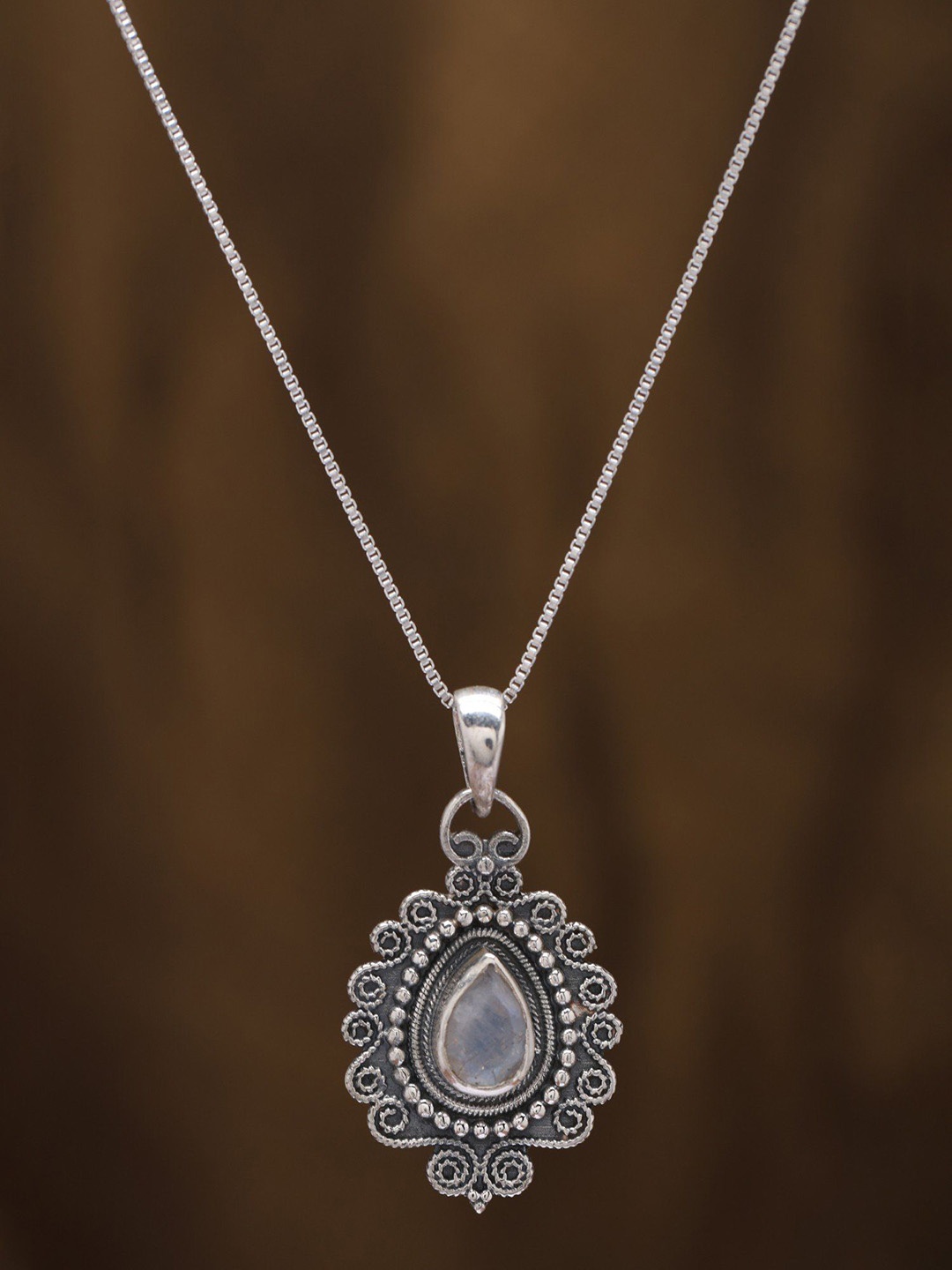 

Exotic India Sterling Silver Pendant with Tear drop Shape Rainbow Moonstone