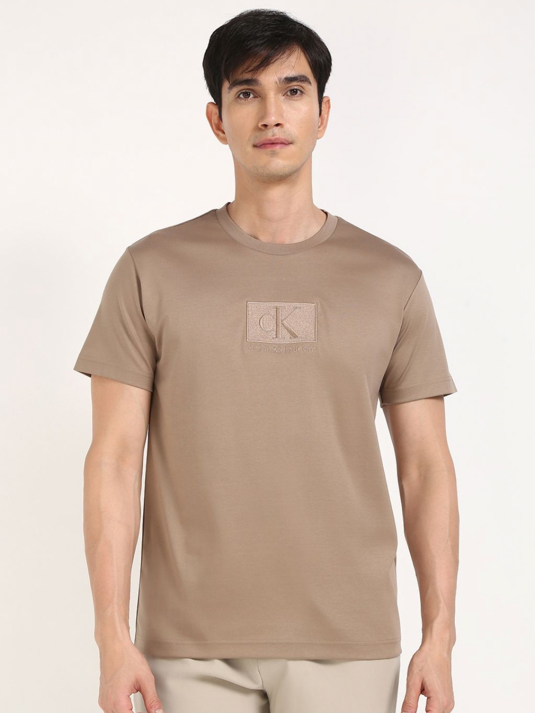 

Calvin Klein Jeans Men Typography Printed Round Neck Cotton T-shirt, Brown