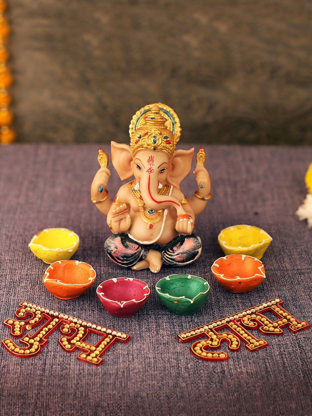 

TIED RIBBONS Gold-Toned Diwali Special Ganesh Idol Showpiece with Multi-Coloured Terracotta Diyas & Shubh Labh Stickers