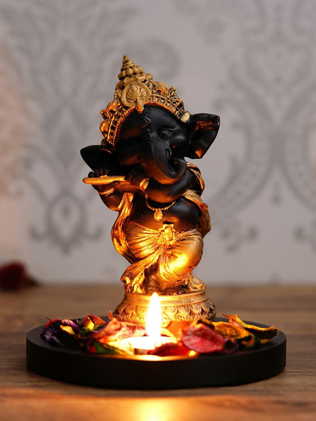

eCraftIndia Gold-Toned & Black Lord Ganesha Dancing Avatar Decorative Showpiece With Wooden Base Petals & Tealight