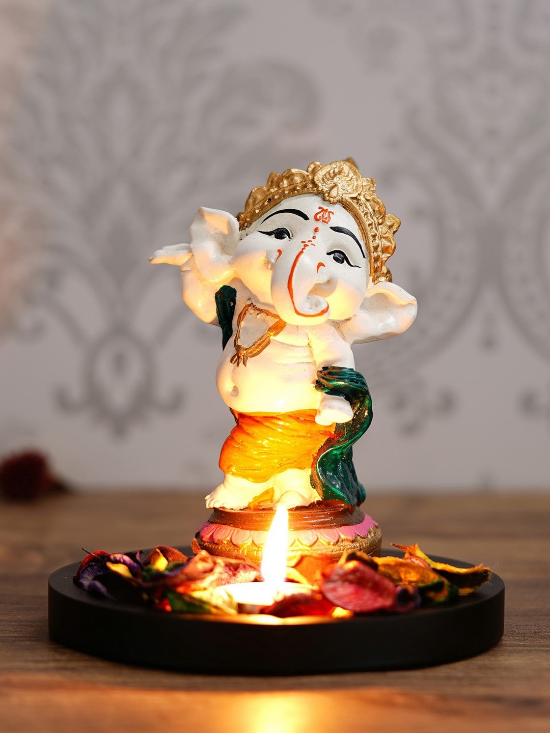 

eCraftIndia Off-White & Orange Lord Ganesha Dancing Avatar Showpiece With Wooden Base, Petals & Tealight