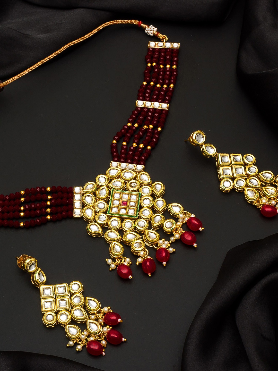 

Aadita Gold-Toned Red & Silver-Coloured Kundan Studded Beaded Jewellery Set