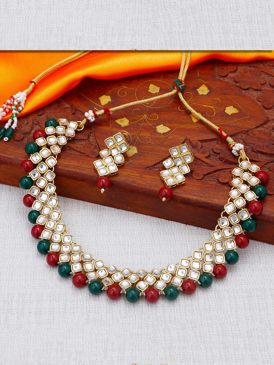 

Sukkhi Gold-Plated White Kundan-Studded & Red & Green Beaded Jewellery Set