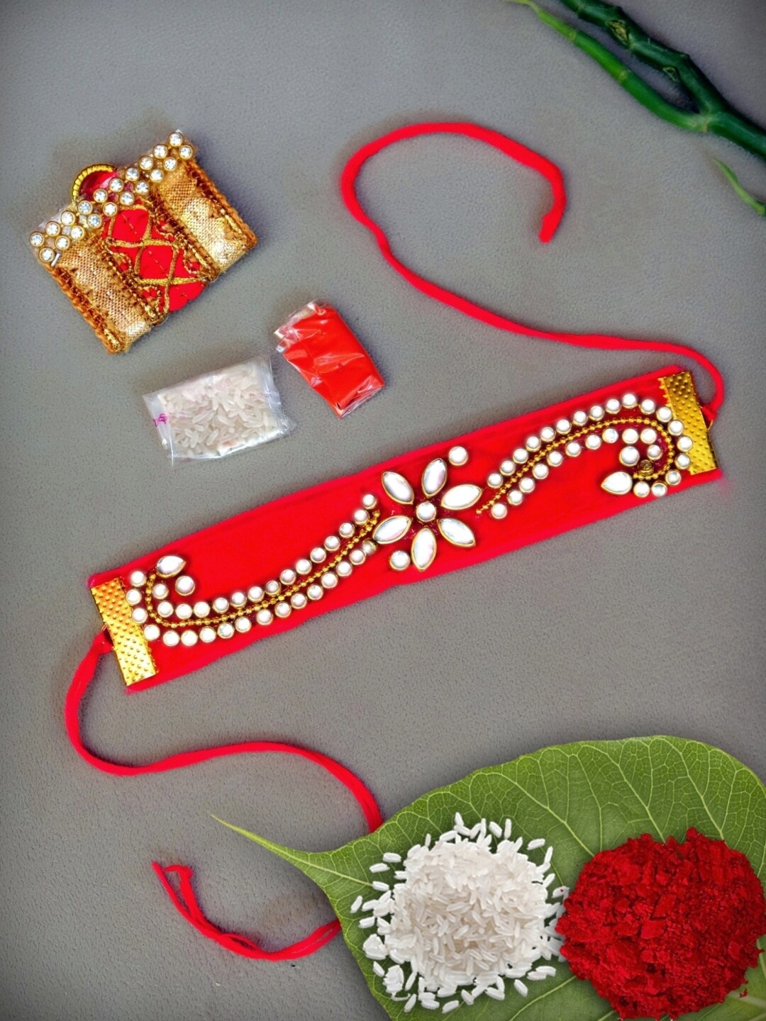 

Crunchy Fashion Red Kundan Stone Braclete Designer Rakhi With Roili & Chawal