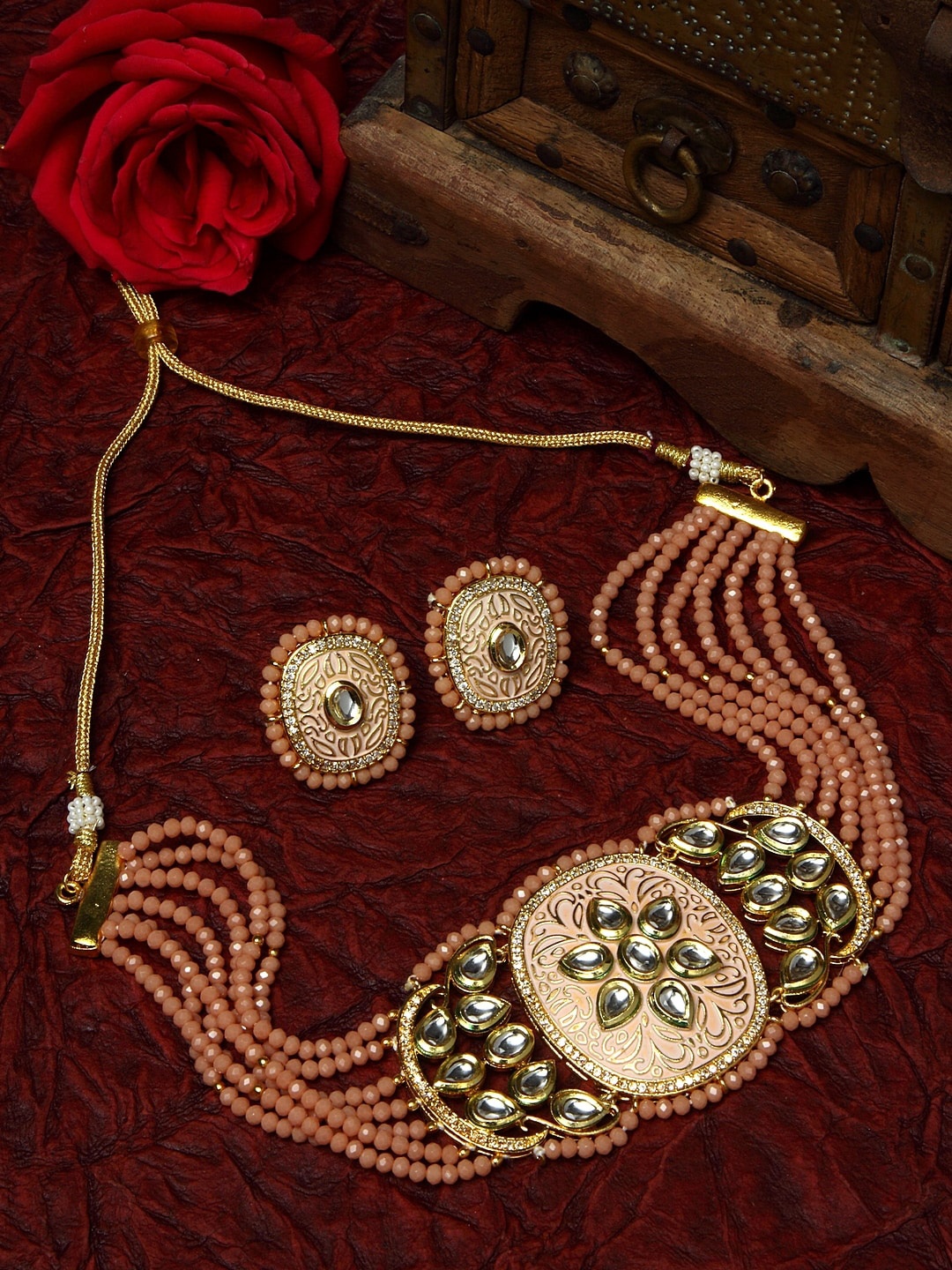 

Moedbuille Gold-Plated Peach-Coloured & White Kundan & Onyx-Studded & Beaded Hand Painted Meenakri Jewellery Set