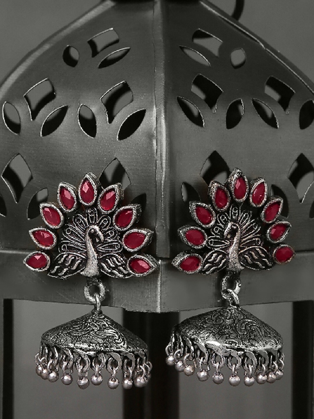 

OOMPH Silver Toned & Maroon Peacock Shaped Faux Ruby Oxidized Jhumkas Earrings