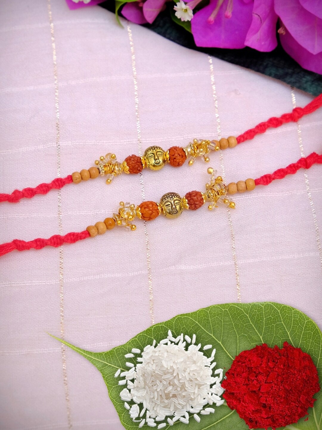 

Crunchy Fashion Pack of 2 Designer Rudraksh & Lord Gautam Budh Rakhis WIth Roli & Chawal, Orange