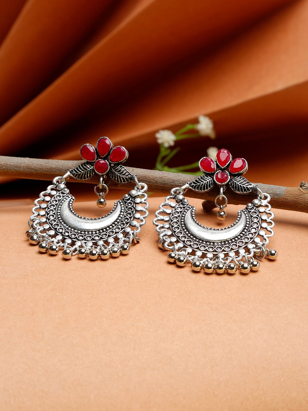 

NEUDIS Silver-Toned & Red stone Studded Oxidised Floral Chandbalis Earrings