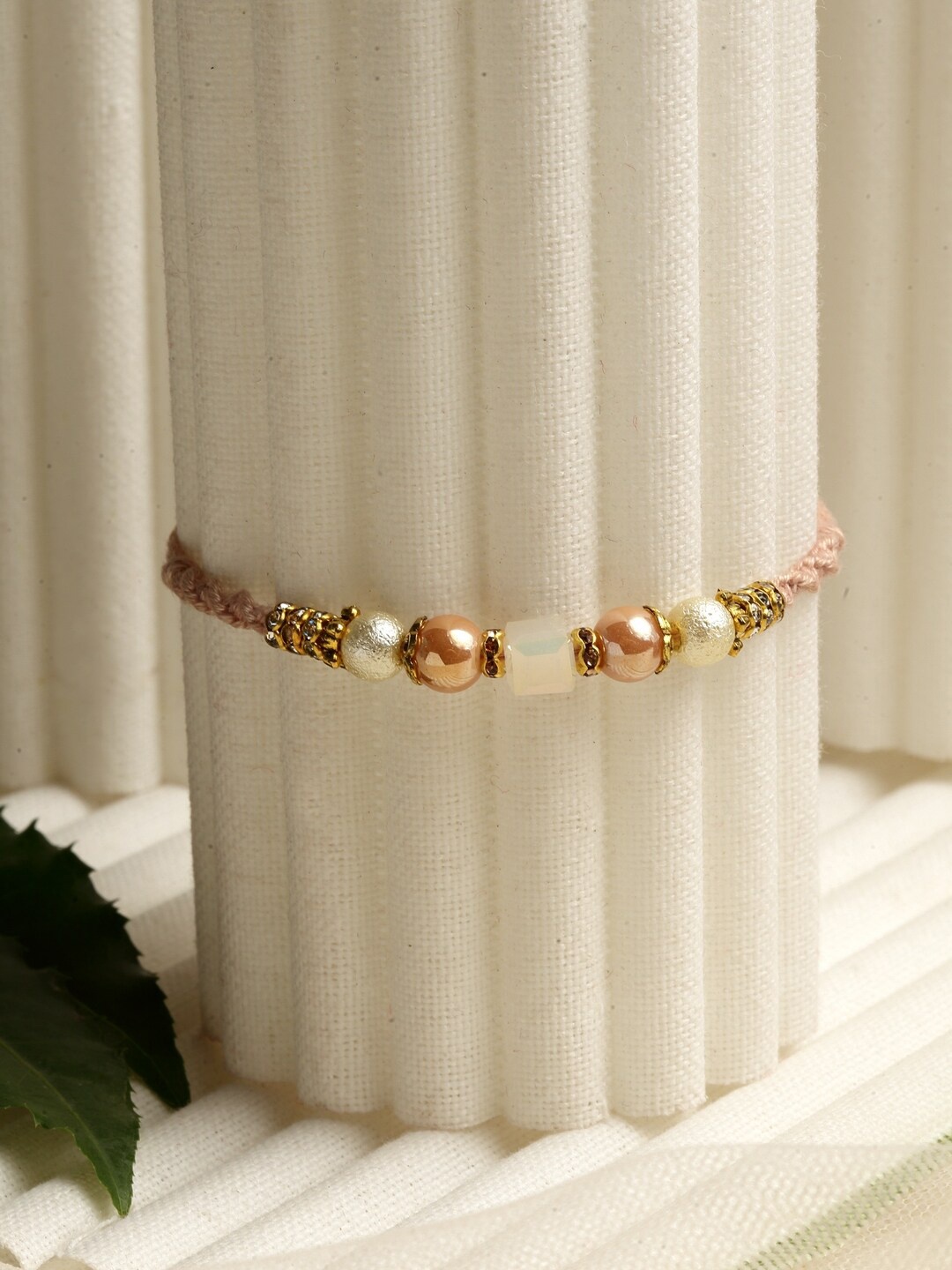 

PANASH Beige & Gold-Toned Beaded Pearl Fashion Rakhi With Roli Chawal