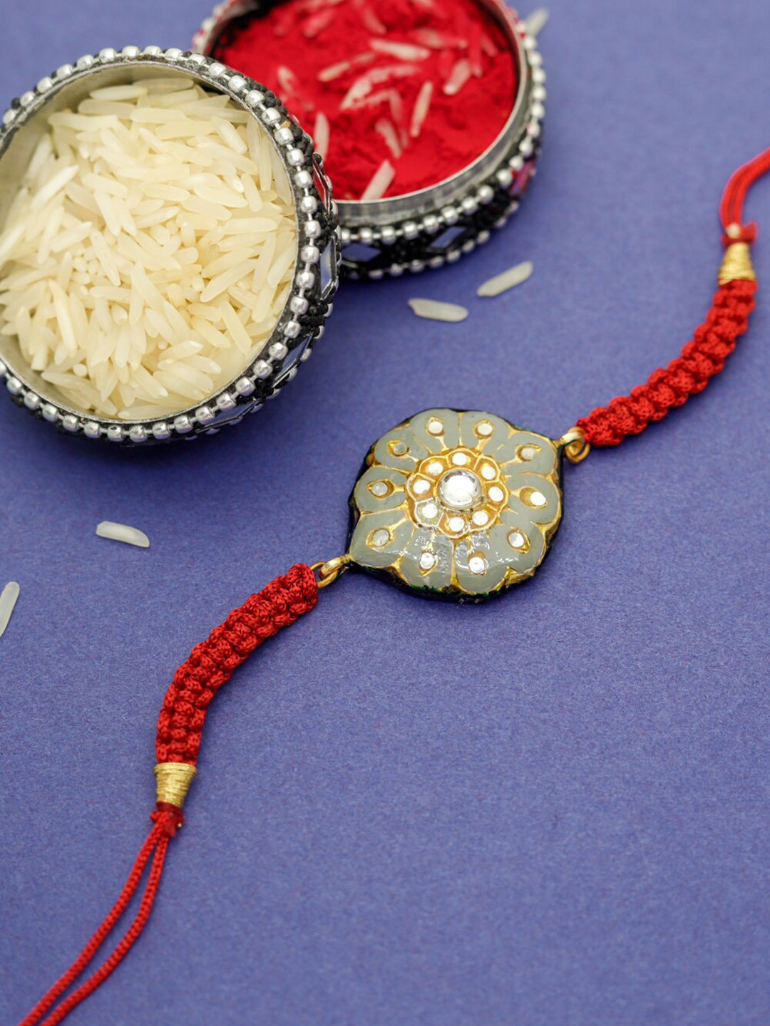 

Shoshaa Grey & Red Kundan Reversible Design Meenakari Rakhi With Roli Chawal