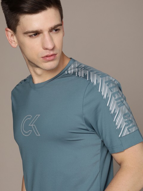 

Calvin Klein Jeans Men Blue & Bronze-Toned Brand Logo Printed T-shirt
