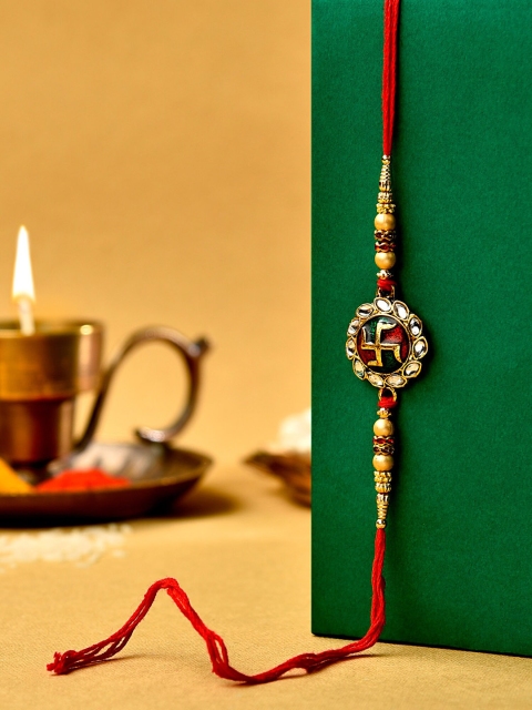 

Zaveri Pearls Red & Green Enamelled Kundan Swastik Rakhi With Chawal Roli
