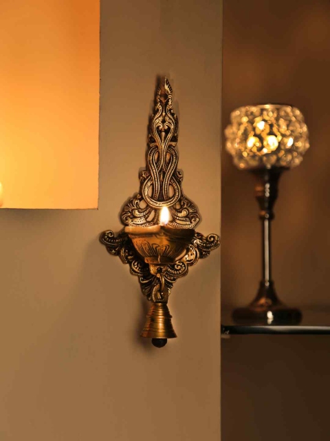 

Amoliconcepts Gold-Toned Traditional Peacock Diya with bell Wall Lamp