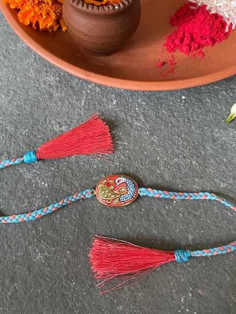 

Mitali Jain Orange Tanjore Rakhi