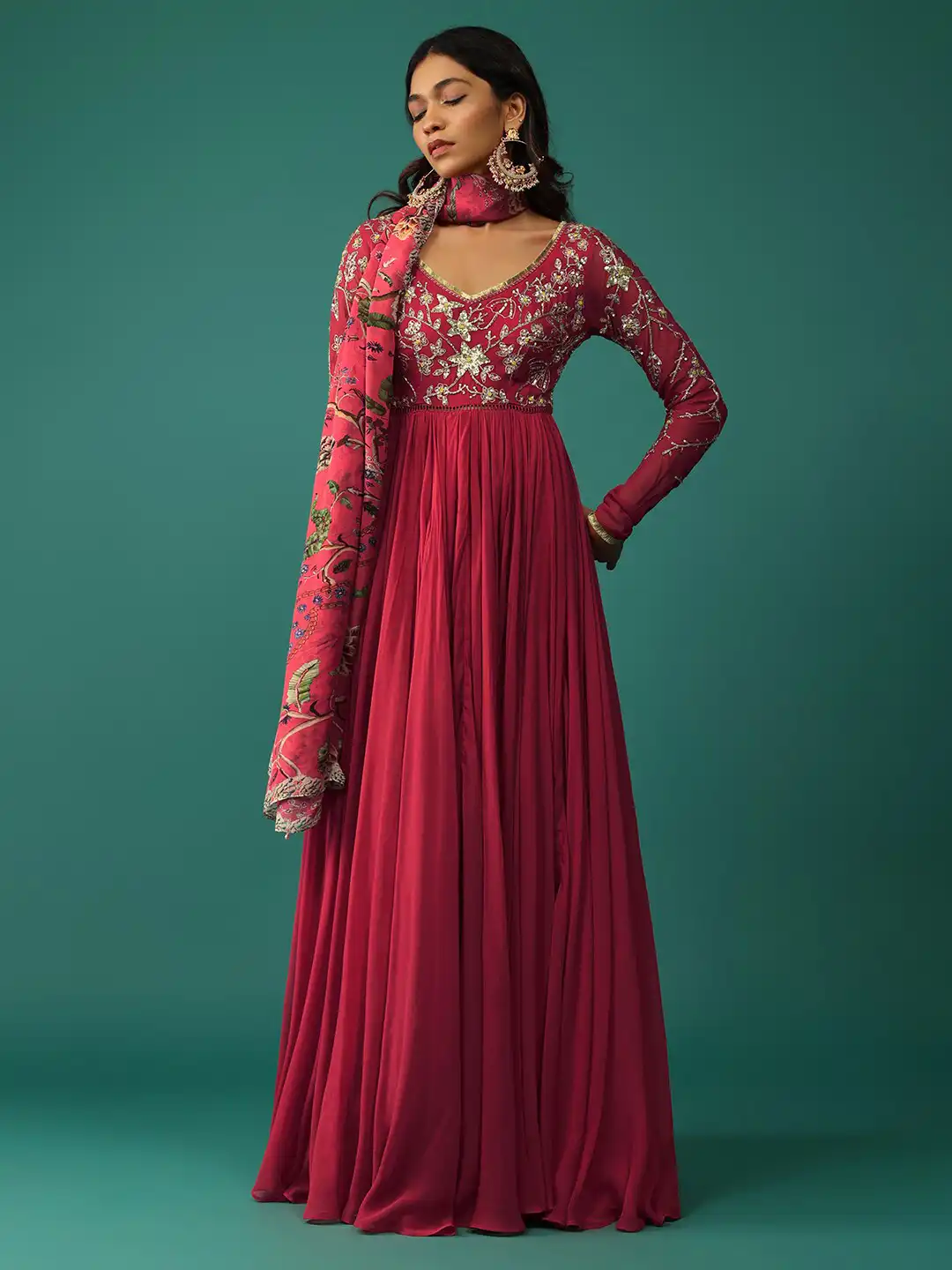 kalki red dress Deep Red Embellished Trail Gown A silhouette steeped in allure, this deep wine creation fuses mystery with command. The sculpted bodice embraces the form like armor, while the daring slit adds a